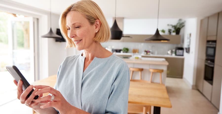 Woman holding a mobile device in a modern home